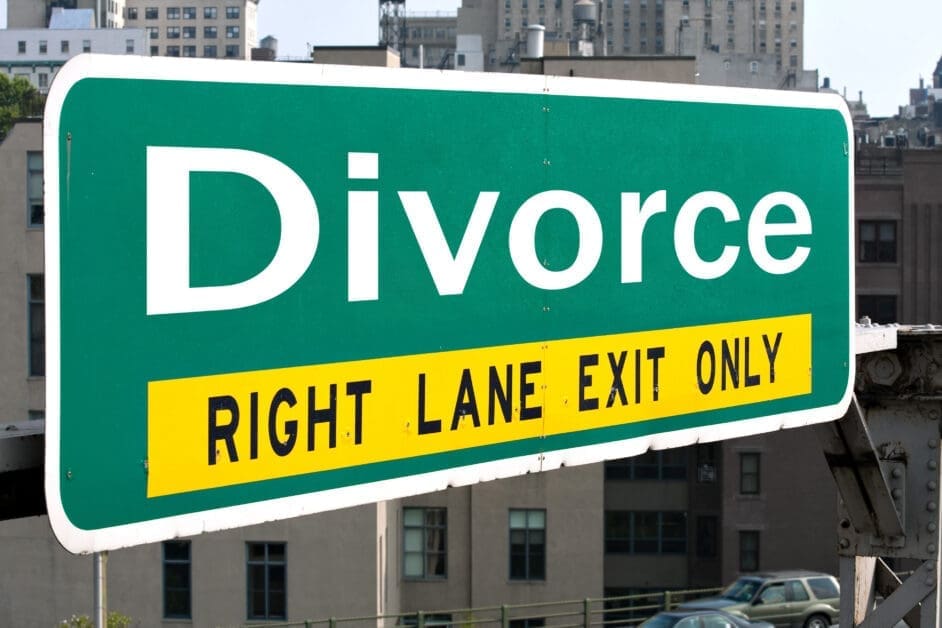 Large green highway sign reading 'Divorce' with a yellow 'Right Lane Exit Only' banner, urban backdrop