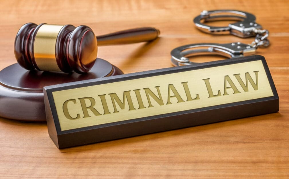 - Attorneys.Media - Legal Expert Interviews & Trusted Advice Gavel and Handcuffs on a Wooden Desk with a Gold 'criminal Law' Nameplate in the Foreground.