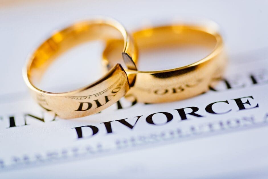 Two Gold Wedding Bands Resting on a Divorce Document, Symbolizing Separation or Dissolution of Marriage.